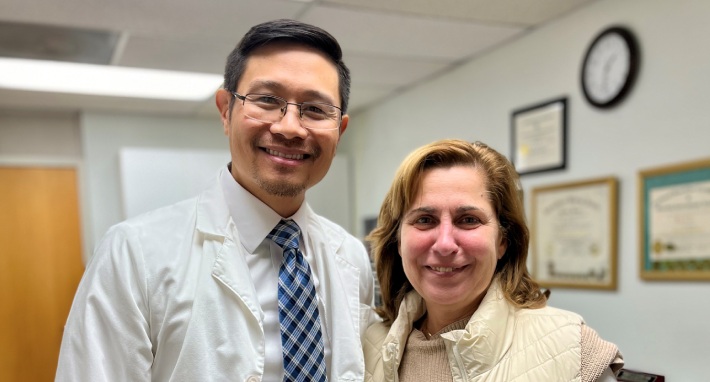 Alex HIS, taking photo with patient wearing white sweater